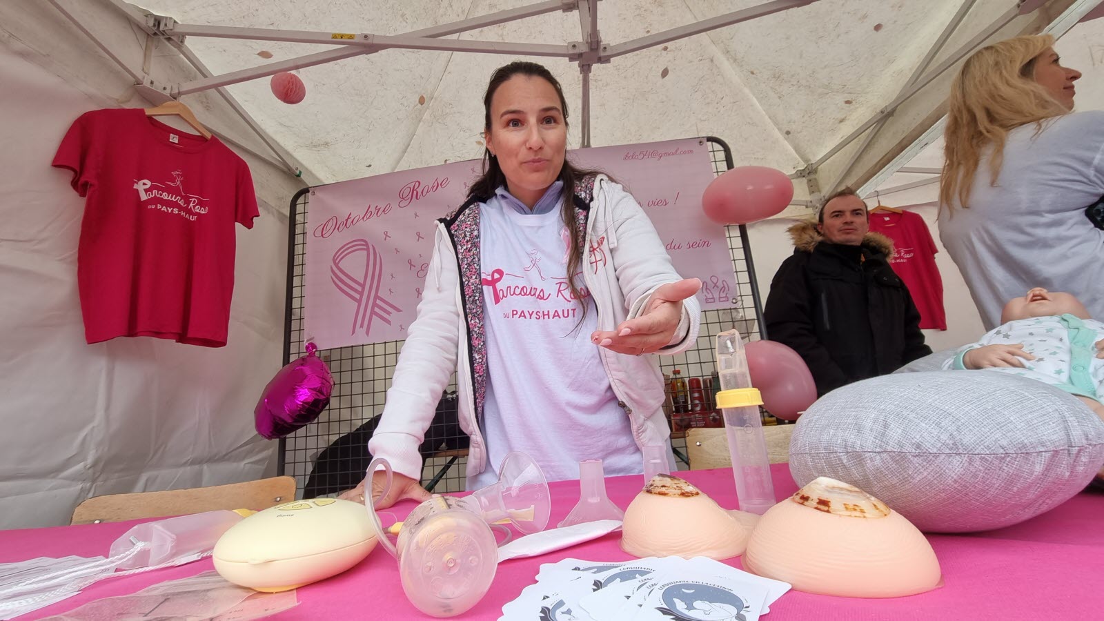 Bénédicte Lardenois, consultante IBCLC, sur le stand d'information allaitement du Parcours Rose Pays-Haut 2023 à Saulnes, avec du matériel de démonstration.